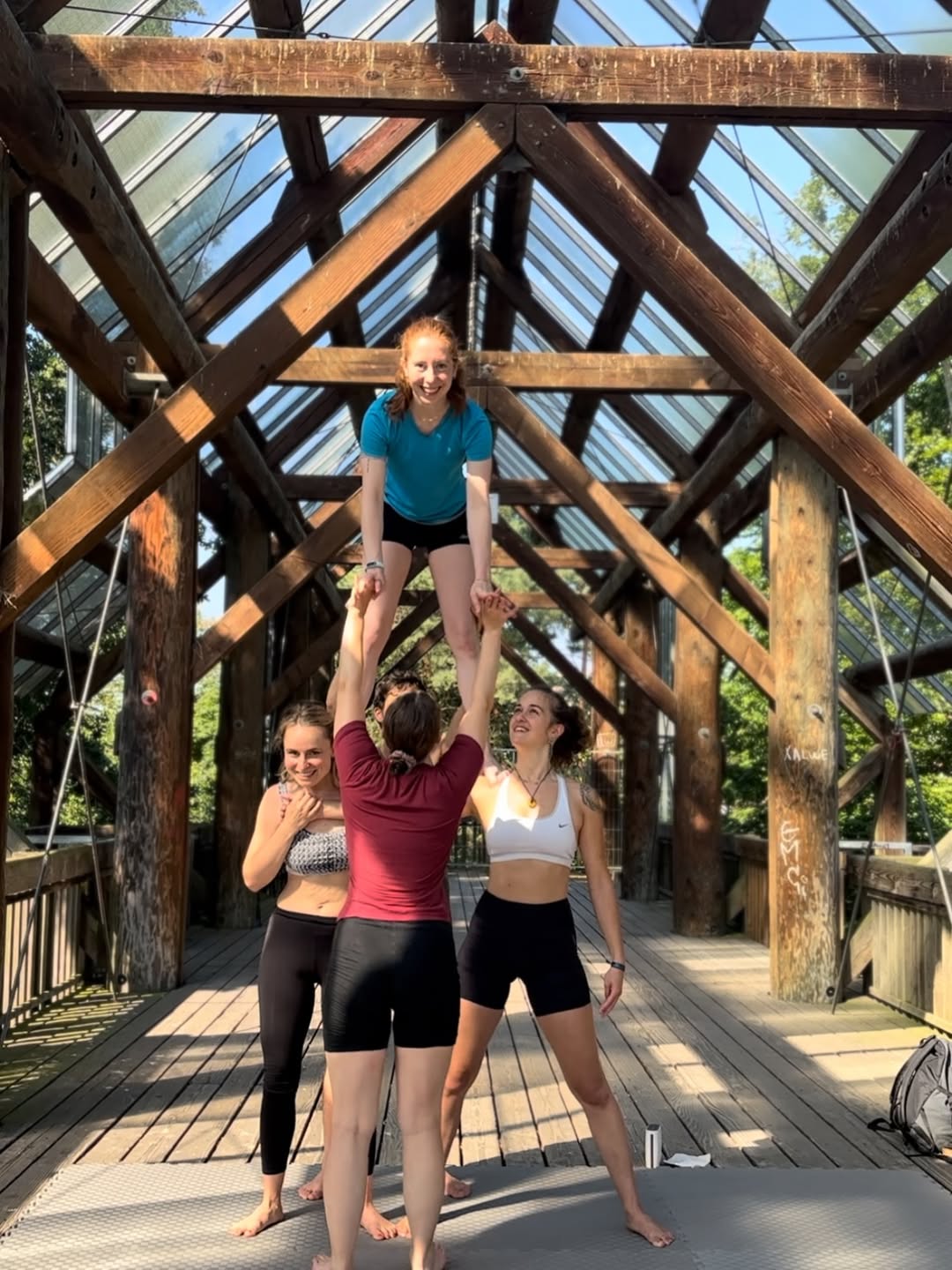 Stehende AcroYoga-Pose an der überdachten Brücke