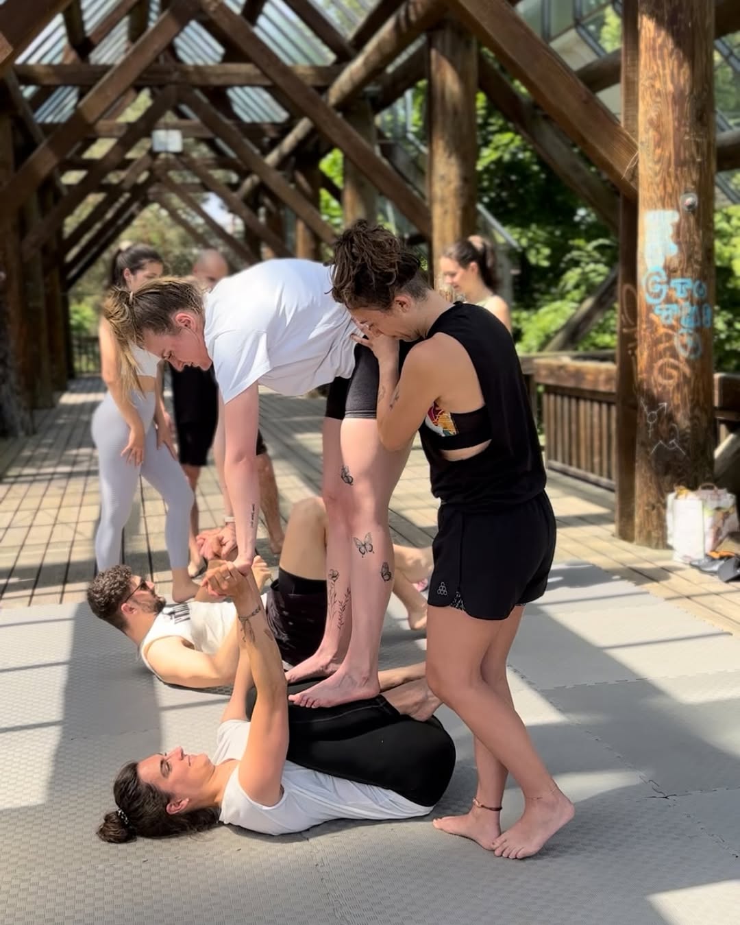 Eine Flyerin wird in einer AcroYoga-Stunde im Seepark Glashaus gespottet